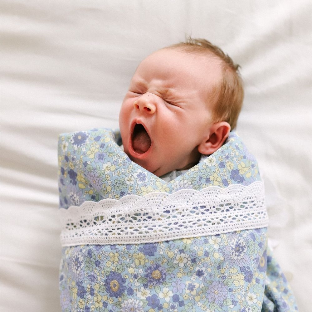Newborn photography wrapped in a lace edged floral blanket made in Australia