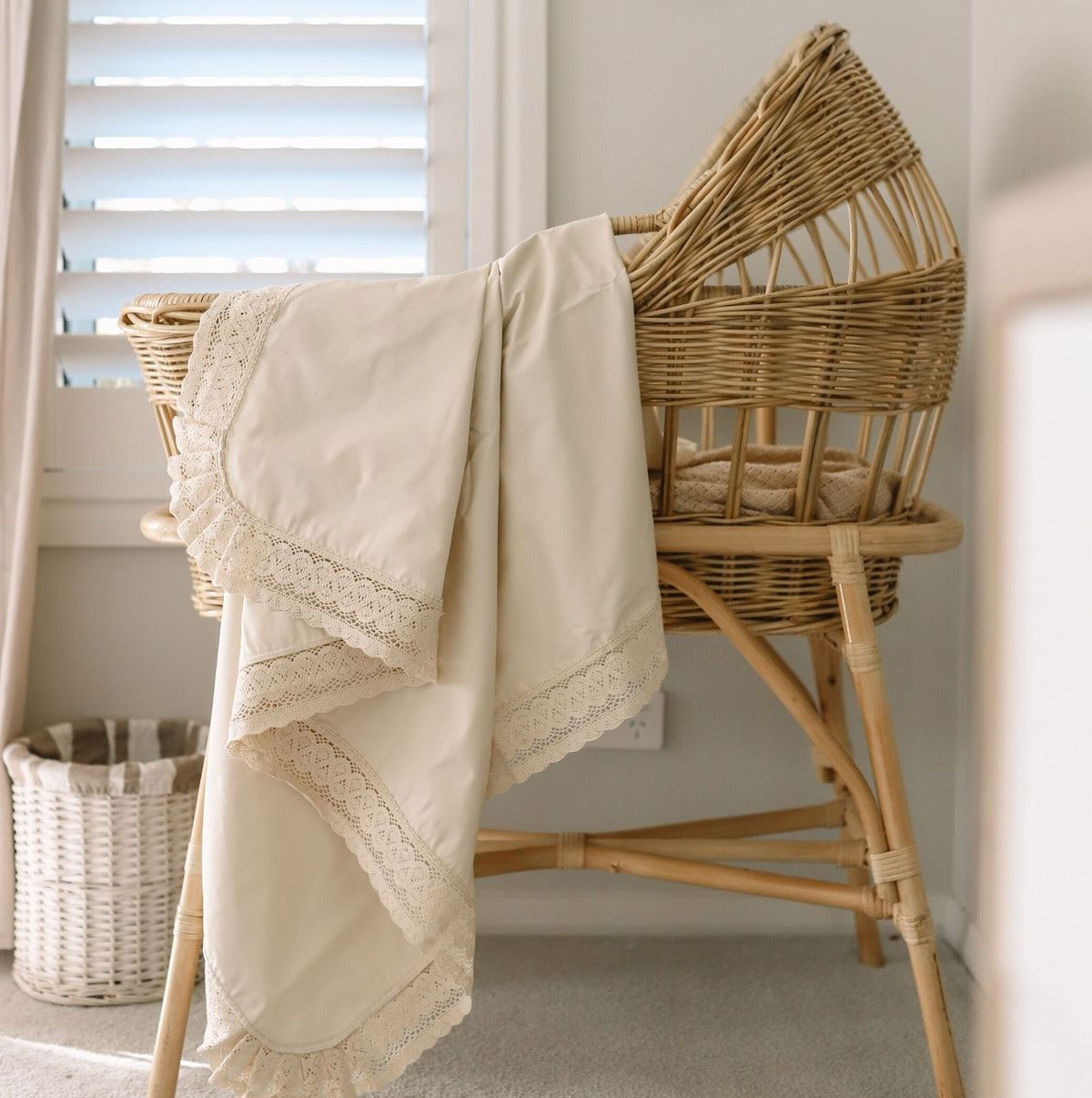 Cream colour lace edged baby blanket or swaddle hanging in a nursery nook